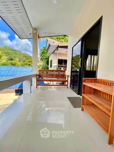 Spacious balcony with scenic view and wooden furniture, perfect for relaxation.