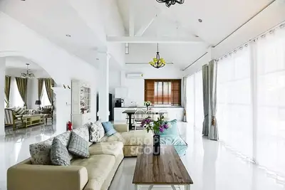 Spacious open-plan living room with elegant decor and abundant natural light