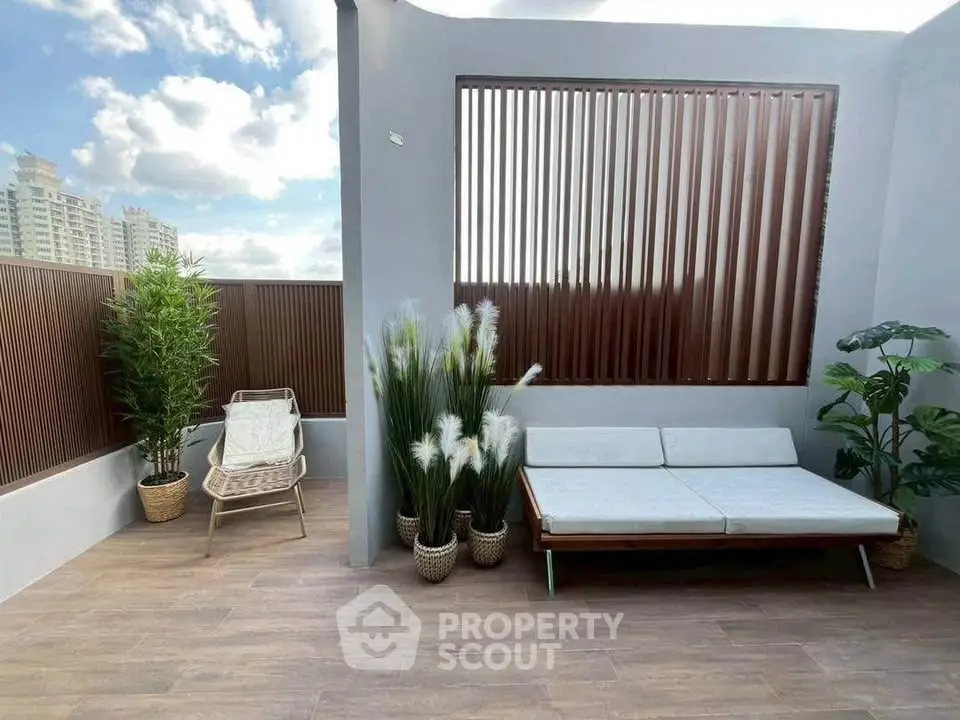 Stylish rooftop terrace with modern seating and lush greenery, perfect for relaxation.