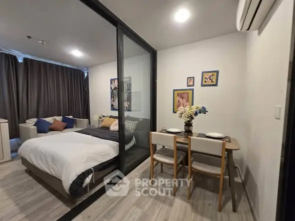 Modern studio apartment with cozy bedroom and dining area, featuring stylish decor and ample natural light.