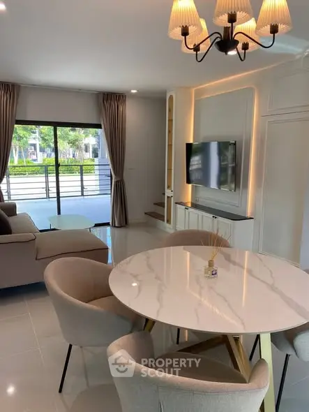 Modern living room with elegant dining area and large windows offering natural light.