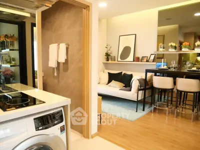 Modern open-plan living room with stylish kitchen and washing machine