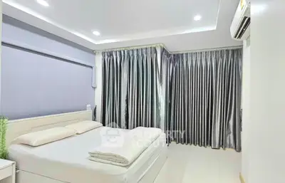 Spacious bedroom with modern decor and large windows in a stylish apartment.