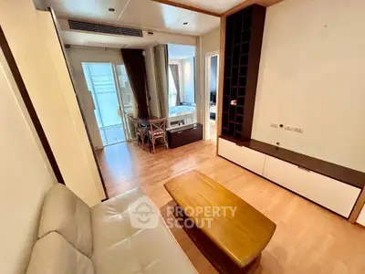 Spacious living room with modern decor and wooden flooring in a stylish apartment.