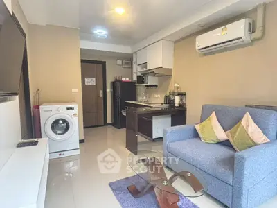 Modern living room with compact kitchen and washing machine in cozy apartment