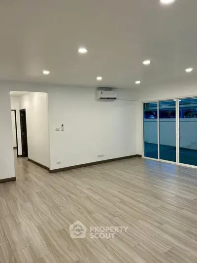 Spacious modern living room with sliding glass doors and sleek flooring