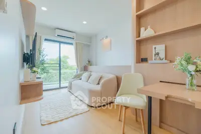 Bright and cozy living room with modern decor and large window view.