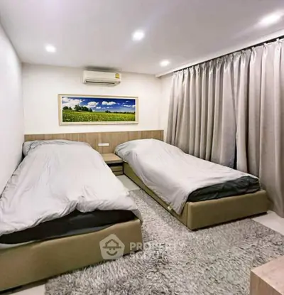 Cozy bedroom with twin beds, modern decor, and soft lighting for a relaxing ambiance.