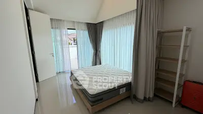 Spacious bedroom with large windows and modern minimalist design, featuring a comfortable mattress and sleek shelving.