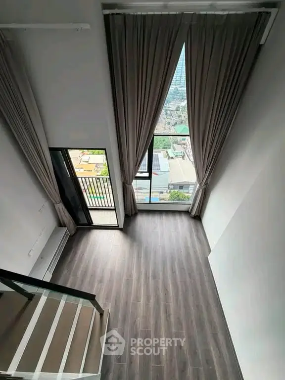 Spacious loft with high ceilings and large windows offering stunning city views.