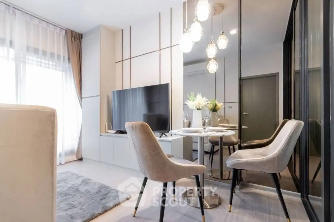 Modern living room with stylish decor and large TV, featuring elegant lighting and cozy seating.