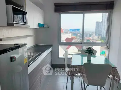 Modern kitchen with dining area and city view, featuring sleek cabinetry and stainless steel appliances.