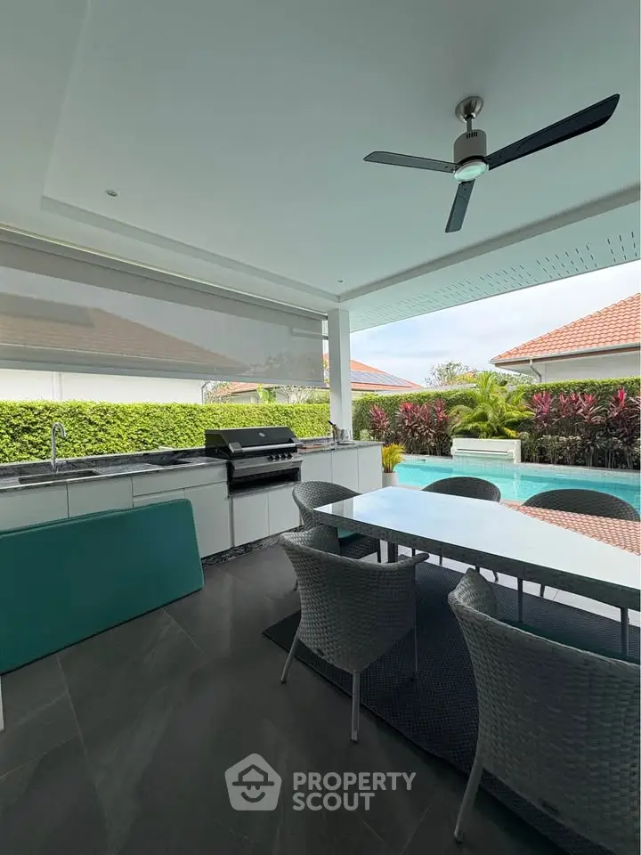 Luxurious outdoor patio with modern dining area and pool view, perfect for entertaining.