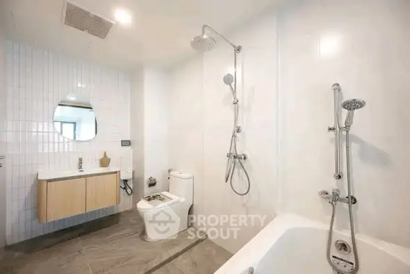 Modern bathroom with sleek fixtures and a spacious layout, featuring a bathtub and stylish vanity.