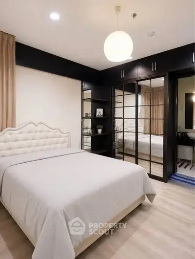 Elegant bedroom with modern decor and mirrored wardrobe doors
