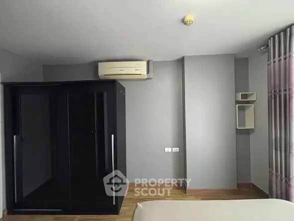 Spacious bedroom with modern wardrobe and air conditioning unit