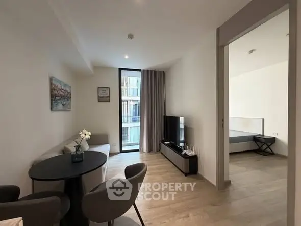 Modern living room with dining area and view into bedroom