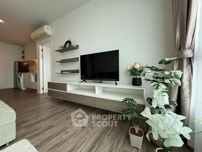 Modern living room with sleek TV unit, wooden flooring, and lush indoor plants for a cozy ambiance.