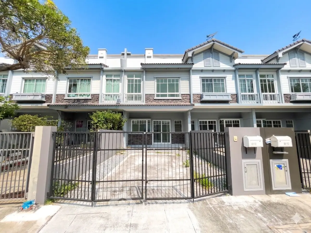 Charming townhouse with modern facade and spacious driveway in a serene neighborhood.
