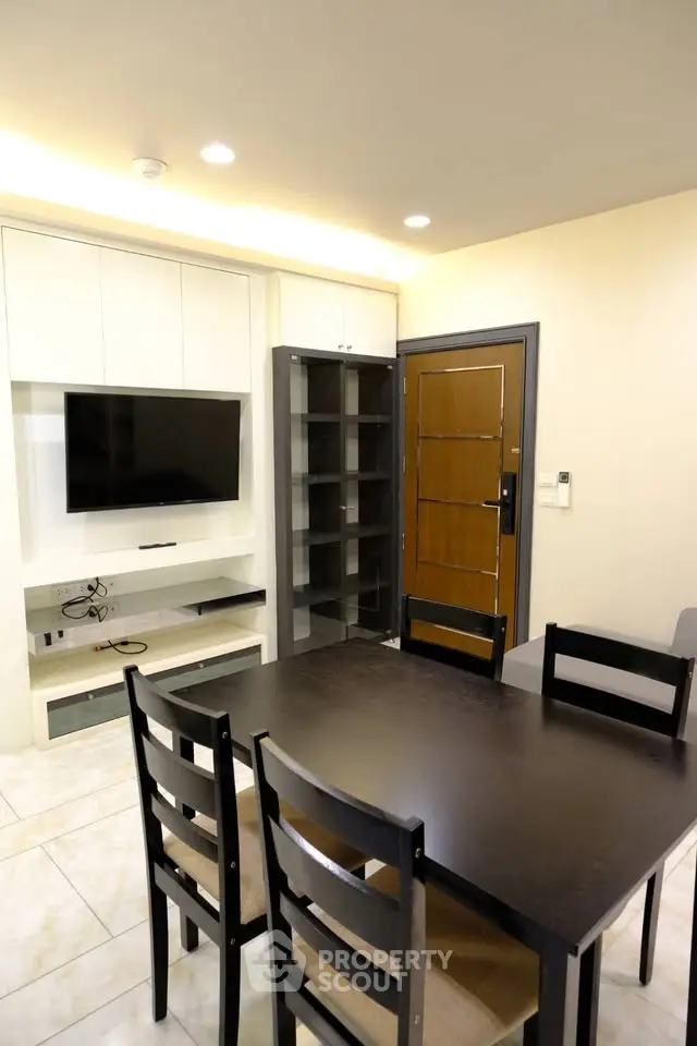 Modern dining area with sleek furniture and built-in TV unit