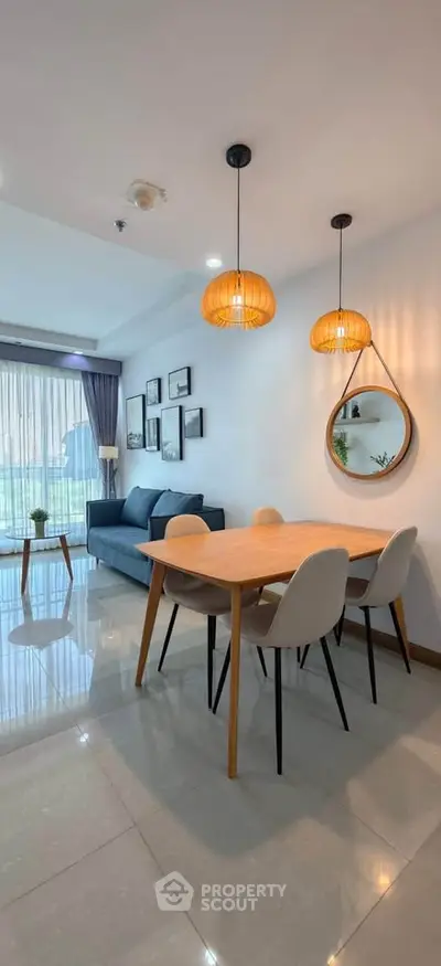 Modern living room with stylish dining area and cozy seating, featuring elegant lighting and contemporary decor.