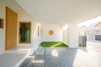Modern minimalist home entrance with open-air design and natural light.