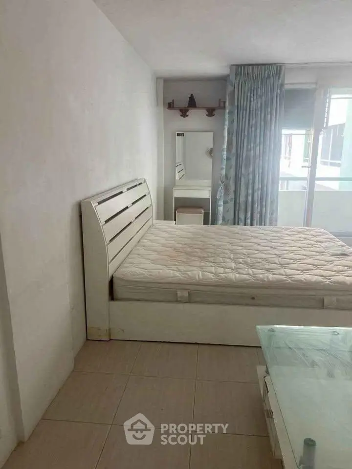 Spacious bedroom with modern decor and natural light, featuring a comfortable bed and stylish furnishings.