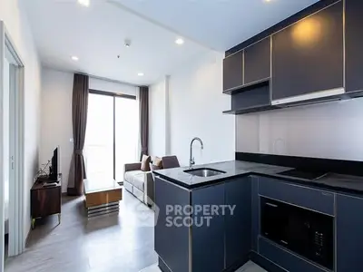 Modern open-layout kitchen and living room with sleek design and natural light.