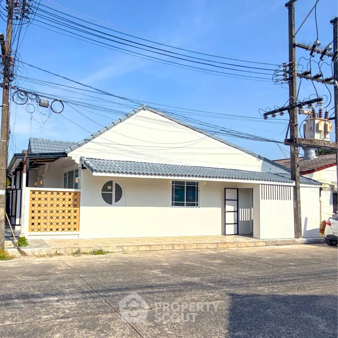Charming single-story house with modern facade and spacious driveway.