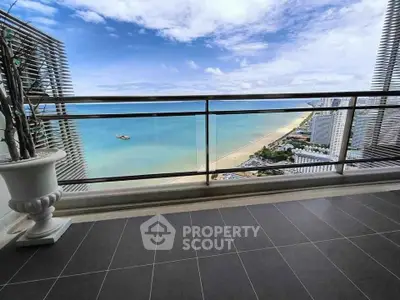 Stunning balcony view overlooking a pristine beach and ocean horizon.
