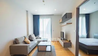 Modern living room with sleek furniture and large windows offering natural light.