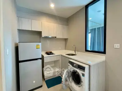 Modern kitchen with washing machine and fridge in compact apartment