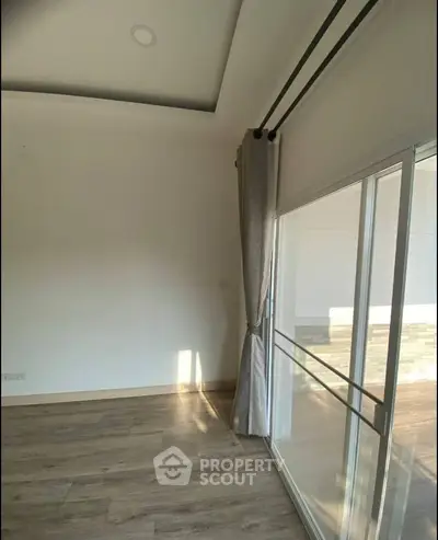 Spacious room with large sliding glass doors and elegant curtains, perfect for natural light.