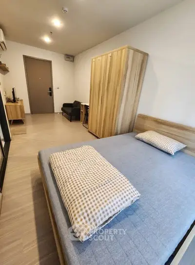 Modern bedroom with wooden furniture and cozy ambiance in a stylish apartment.