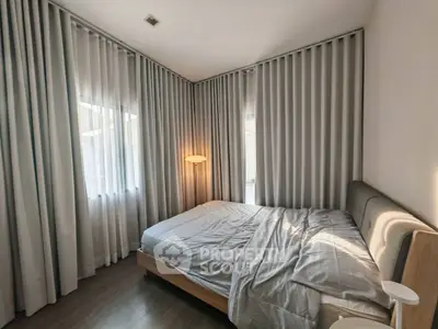 Cozy bedroom with modern decor and soft lighting, featuring floor-to-ceiling curtains and a comfortable bed.