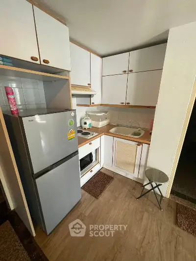 Cozy kitchen with modern appliances and wooden flooring in a compact layout.
