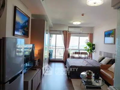 Modern studio apartment with cozy living area and scenic balcony view
