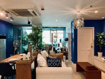 Stylish modern living room with blue accents and open layout, featuring elegant furniture and natural light.