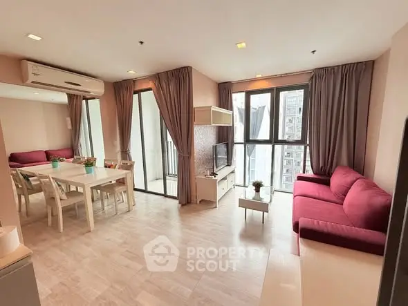 Spacious modern living room with large windows and stylish furniture in a high-rise apartment.