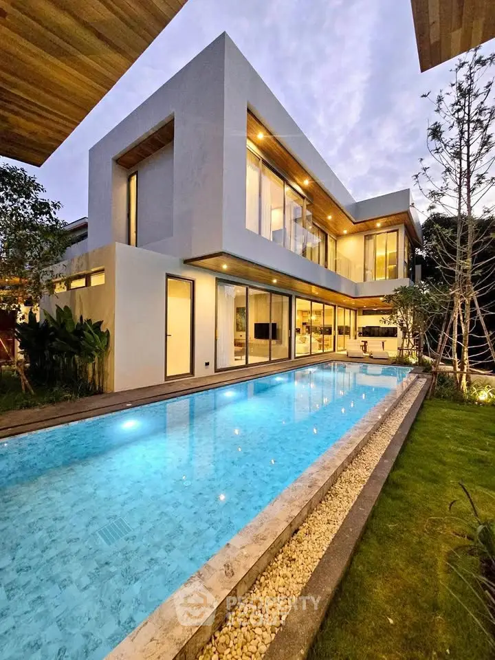 Luxurious modern home with stunning pool and elegant architecture at dusk.