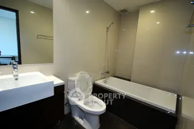 Modern bathroom with sleek fixtures and bathtub in contemporary apartment.