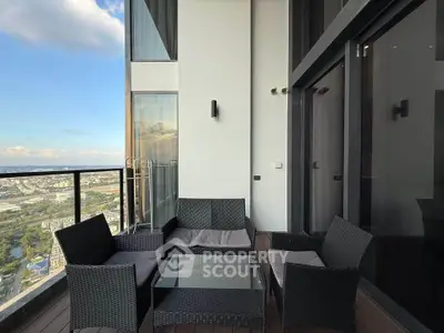Luxurious high-rise balcony with stunning city view and modern outdoor seating.