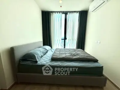 Modern bedroom with stylish bed and natural light from large window.