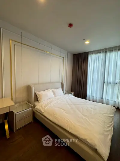 Luxurious bedroom with elegant decor and large window for natural light.