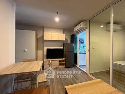 Modern living room with open layout, featuring sleek furniture and air conditioning, ideal for urban living.