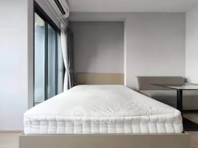 Modern bedroom with large window and minimalist decor, perfect for urban living.
