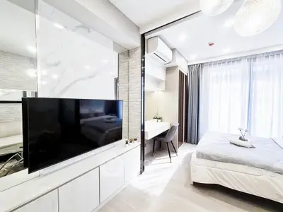 Modern studio apartment with sleek design, featuring a cozy bedroom and stylish living area.