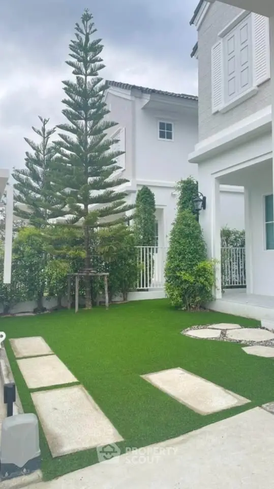 Charming residential garden with lush greenery and modern architecture.