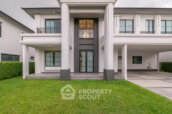 Elegant modern house exterior with manicured lawn and spacious driveway.