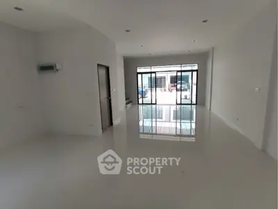 Spacious modern living room with large windows and glossy white flooring